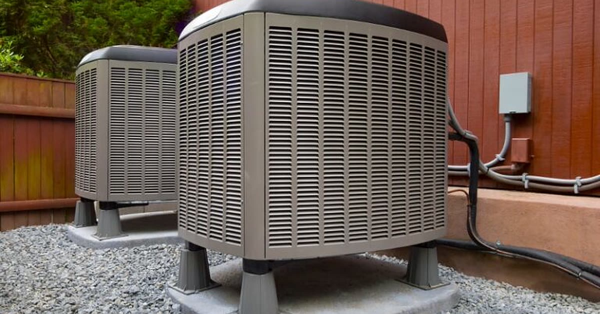 Two newly installed air conditioning condenser units on concrete pads at an Arizona home