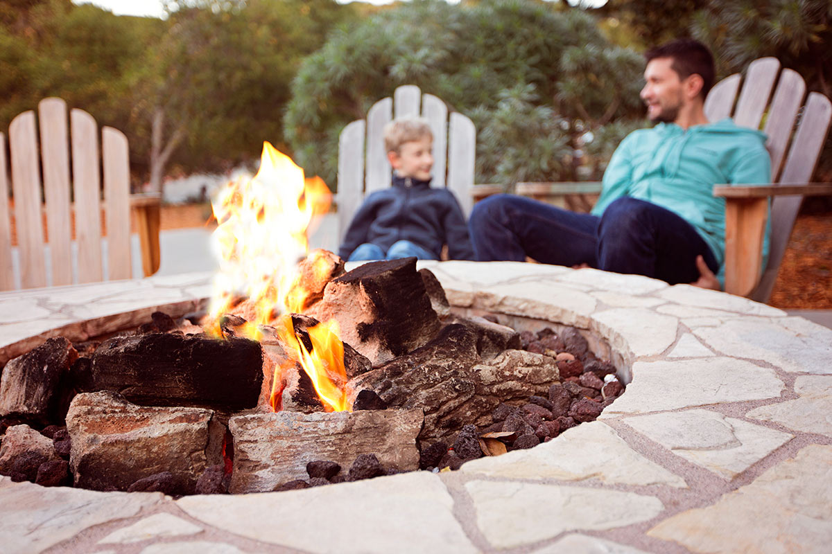 Father and Son around the campfire in fall